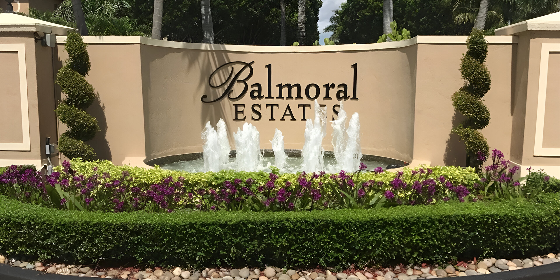 A sign that says balmoral estates with some water fountains